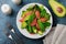 Useful tasty salad of spinach, chard, avocado and grapefruit with olive oil on an old concrete dark background. Selective focus.