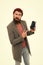 User outraged. Man brutal bully appearance hold smartphone isolated white. Bearded brutal guy pointing at smartphone