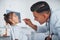 Uses tonsil to check throat. Young pediatrician works with little female visitor in the clinic