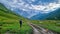 Ushguli - A man and a dog walking on a trail in the Greater Caucasus Mountain Range in Georgia.