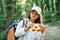 Using the binoculars. Girl is in the forest at summer day time discovering new places