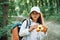 Using the binoculars. Girl is in the forest at summer day time discovering new places