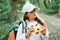 Using the binoculars. Girl is in the forest at summer day time discovering new places