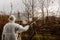 Using chemicals in the garden orchard gardener applying an insecticide a fertilizer to his fruit shrubs, using a sprayer