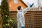 Using chemicals in the garden orchard gardener applying an insecticide a fertilizer to his fruit shrubs, using a sprayer