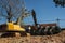 Using an excavator to transfer large pipes to a vehicle.