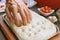 Using fingertips to create dimples in the dough for baking Focaccia Genovese bread