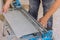 Using manual tools equipment, a construction worker cuts the ceramic tile using manual tools for laying ceramic tiles