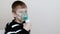 Using nebulizer and inhaler for the treatment. Boy inhaling through inhaler mask. Side view.