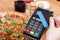 Using payment terminal with contactless credit card for paying in restaurant, finance concept, vegetarian pizza