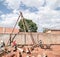 Using a pile driver on a tripod to dig the soil and make the foundation to support the building