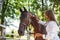 Using stethoscope. Female vet examining horse outdoors at the farm at daytime