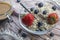 Usual glass bowl with old teaspoon, cereals, strawberries and blueberries, coffee