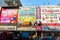 The usual street of the Asian city. Multi-colored low buildings and motorbikes