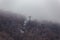 Usuzan Ropeway pole in the mountain with snow and fog on the top and trees below near Noboribetsu Bear Park in Hokkaido, Japan