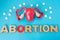 Uterus model with pills as medical abortion concept photo . 3D figure of uterus with ovaries is on blue background with crumbled p