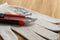 Utility knife, screws and glove on wooden table, closeup