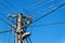 Utility pole or power pole. Column with electric disconnect power. Blue clear sky. Three-phase power line connection.