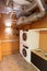 Utility room with two washing machines. There are large pipes on the ceiling