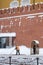 A utility worker cleans snow next to a soldier at a post near the Kremlin wall