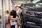 Ðuto mechanic sets the car for diagnostics and configuration collapse-convergence. Car Wheels alignment equipment on stand in a