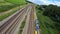 Utrecht, 27th of June 2022, The Netherlands. NS commuter passenger train. FPV race drone follow in a green grassland and