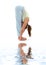 Uttanasana standing forward bend on white sand