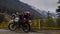 Uttarakhand, India - April 7th, 2021 : Motorbiker travelling, autumn day, motorcycle off road, the driver stands with open arms to