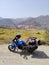 Uttarakhand, India - April 7th, 2021 : Motorbiker travelling, autumn day, motorcycle off road, the driver stands with open arms to