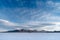 The Uyuni Salt Flats in southwest Bolivia, with mountains, blue sky and wispy clouds in the background