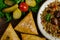 Uzbek national dish of pilaf and samsa on a dark wooden background with pickles