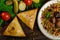 Uzbek national dish of pilaf and samsa on a dark wooden background with pickles