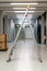 V shaped open ladder standing on a laboratory hallway corridor illuminated by neon lights shallow depth of field side view