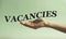 VACANCIES - word on a woman`s hand on a mint background
