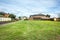 A vacant land with green grass/lawn surrounded by suburban houses in a Melbourne`s suburb. VIC Australia.