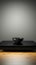 Vacant obsidian table, alone on bright white canvas, minimalist isolation