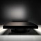 Vacant obsidian table, alone on bright white canvas, minimalist isolation