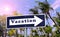 Vacation arrow sign on palm tree background.