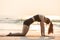 Vacation of Asian woman relaxing in yoga Half bridge pose on sand and beach