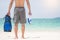 Vacation Backside of man holding snorkeling gear on tropical on