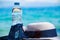 Vacation concept. Essentials on the sea beach. Bottle of drinking water,summer white hat,Plastic bottle with clear water