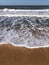 Vacation concept. Minimalist seascape of Crimea with foamy waves on sandy beach and clear blue sky