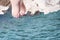 Vacation Concept. Tanning on the Beach. Woman`s Bare Feet over Sea background