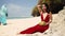 Vacation on exotic island. Beautiful pretty asian woman in hat and red dress drinking coconut on tropical paradise beach