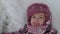 Vacation, game, childhood concept - slo-mo authentic happy preschool toddler baby girl smile lies in snow on back and