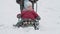 vacation, game, family concept - slo-mo authentic happy smiling young mother pushes sled with toddler preschool son