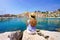 Vacation relax. Girl sitting on stone enjoying landscape of French Riviera on sunny day, Menton, France