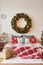 Vacation Rentals. Interior apartment. Christmas bedroom. Bed against background of Christmas tree and wreath. New Year's Eve