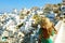 Vacation in Santorini. Happy tourist girl visiting Cyclades Islands, Greece. Young woman on summer holidays discovering Oia famous