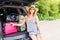 Vacation, Travel - young woman ready for the traveling. suitcases and car